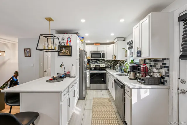 a kitchen with stainless steel appliances a stove a sink and a microwave