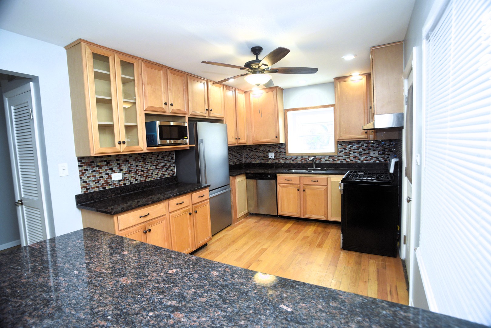 8950 East Prairie Road Evanston, IL 60203 - Photo 9 of 25 a kitchen with stainless steel appliances granite countertop a stove a sink and a refrigerator