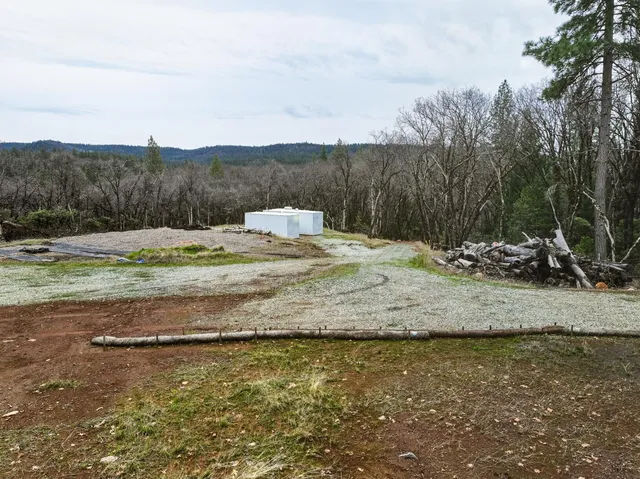 a view of a yard with wooden fence