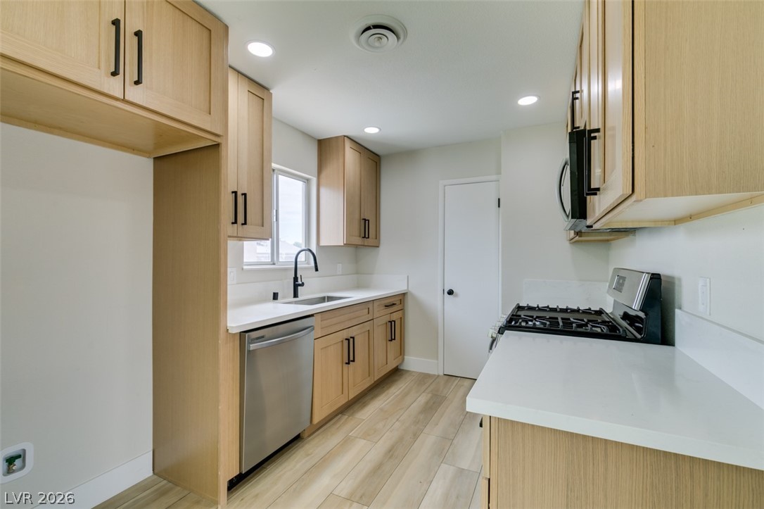 4036 Maple Hill Road Las Vegas, NV 89115 - Photo 22 of 43 Culinary delights await in this light-filled kitchen, boasting ample counter space and modern appliances.