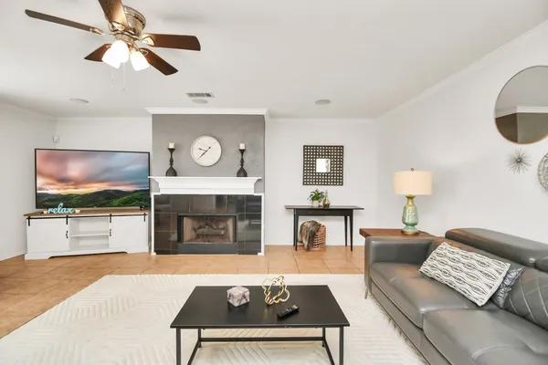a living room with furniture a flat screen tv and a fireplace