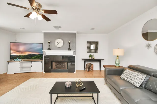 a living room with furniture a flat screen tv and a fireplace