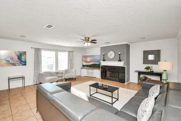 a living room with furniture a fireplace and a large window