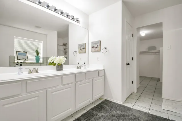 a spacious bathroom with a tub a sink and mirror