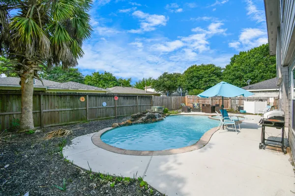 a front view of a house with swimming pool having outdoor seating