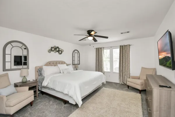 a bedroom with a bed and a flat screen tv