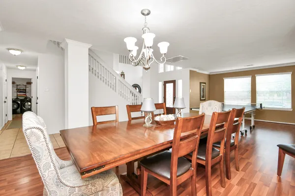 a view of a dining room with furniture a chandelier and wooden floor