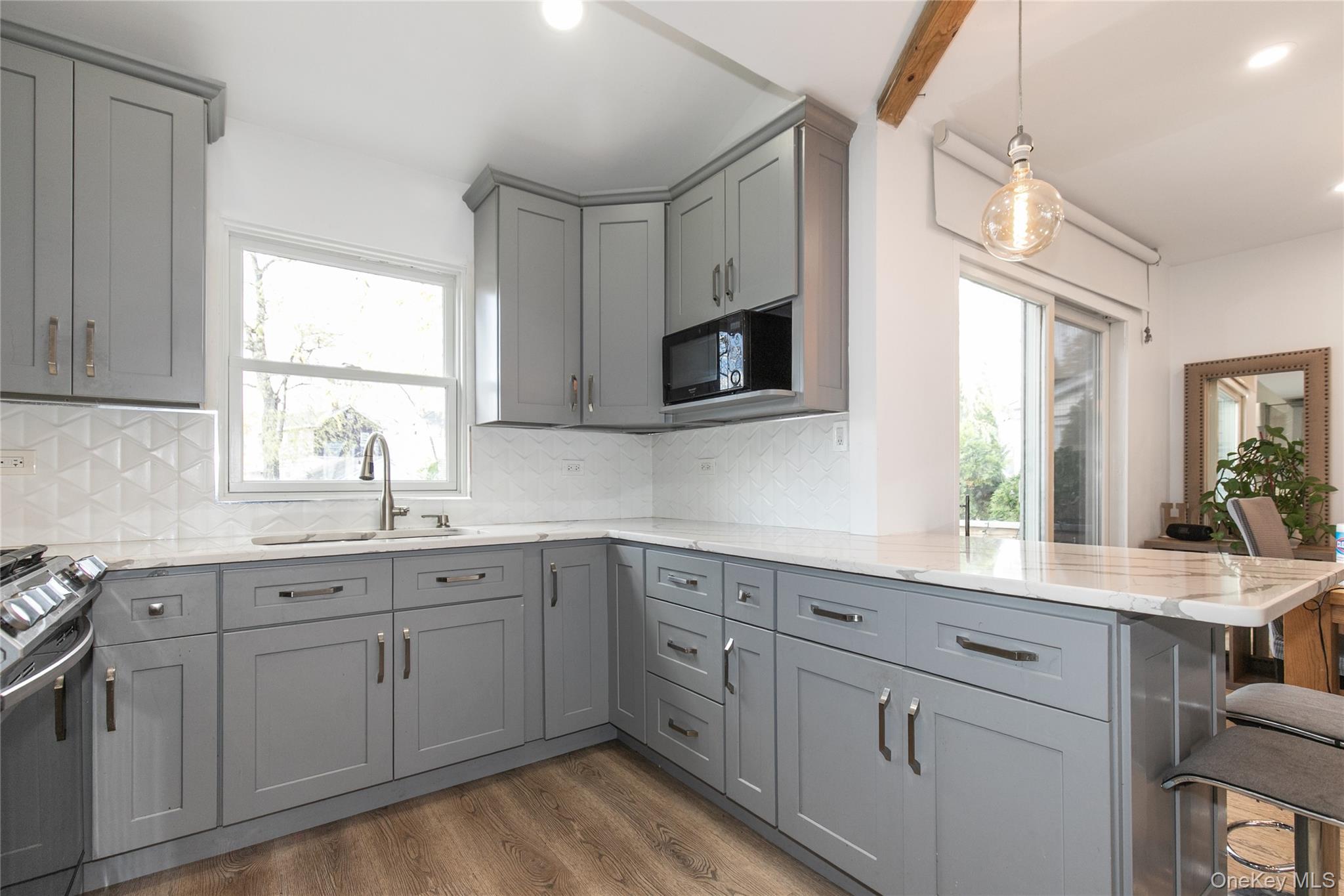 34 Avondale Street Valley Stream, NY 11581 - Photo 9 of 20 a kitchen with white cabinets appliances and a window