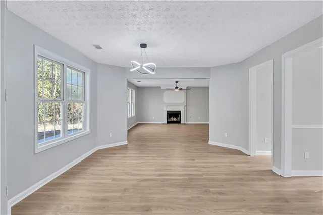 a view of empty room with wooden floor and fireplace