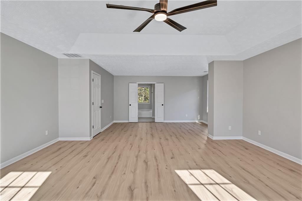 4061 Jewel Terrace Conley, GA 30288 - Photo 19 of 36 a view of empty room with wooden floor and fan