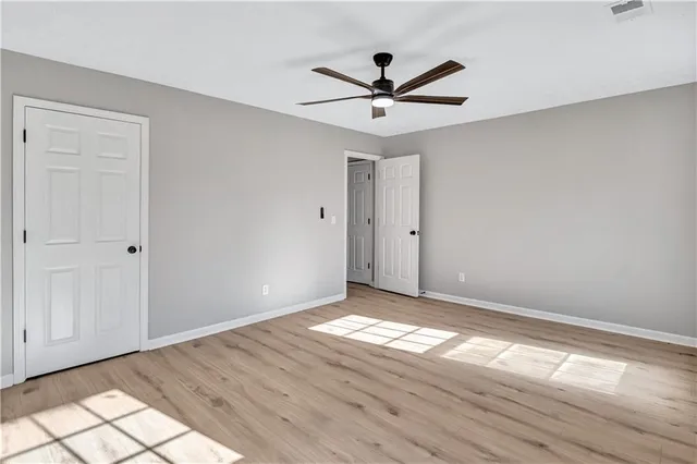 a view of a big room with wooden floor closet and windows