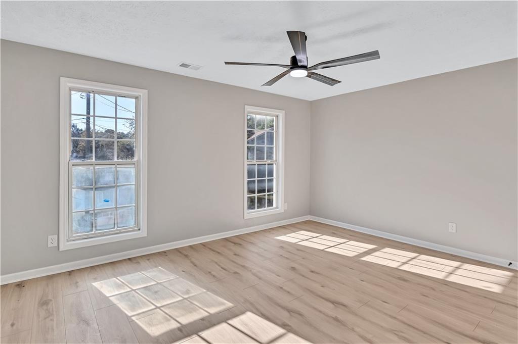 4061 Jewel Terrace Conley, GA 30288 - Photo 27 of 36 a view of empty room with wooden floor and fan