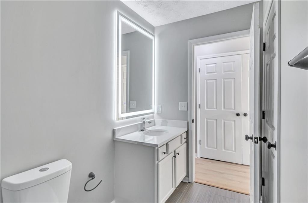4061 Jewel Terrace Conley, GA 30288 - Photo 28 of 36 a bathroom with a granite countertop sink and a mirror