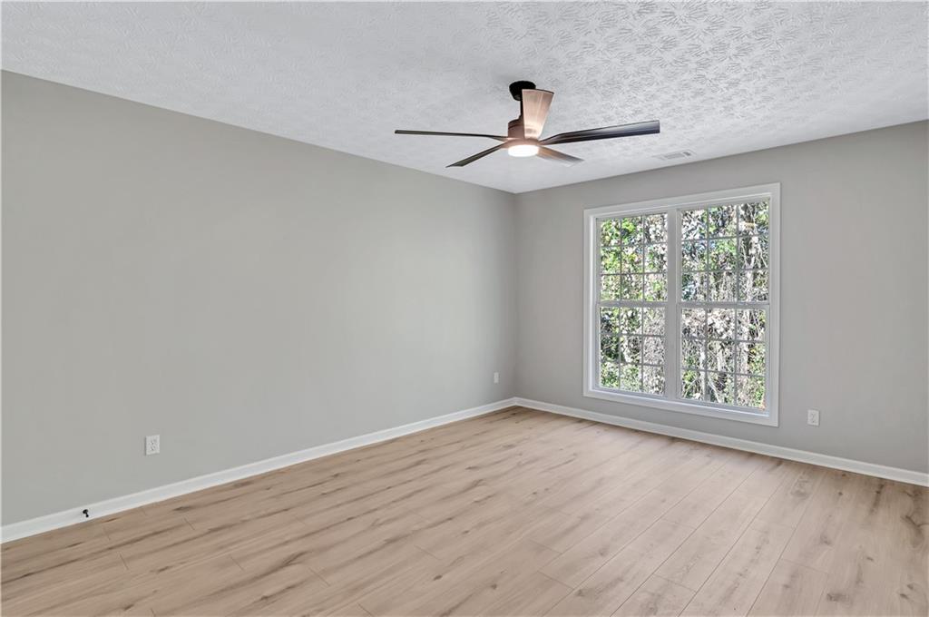 4061 Jewel Terrace Conley, GA 30288 - Photo 31 of 36 an empty room with wooden floor fan and windows