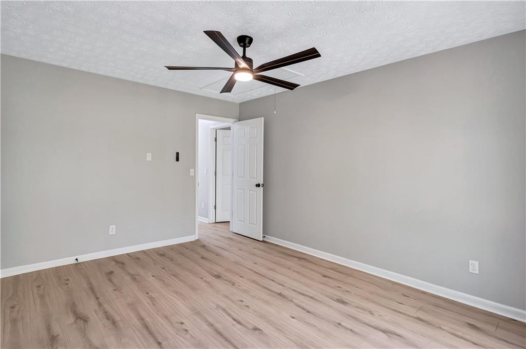 4061 Jewel Terrace Conley, GA 30288 - Photo 32 of 36 an empty room with wooden floor ceiling fan and window