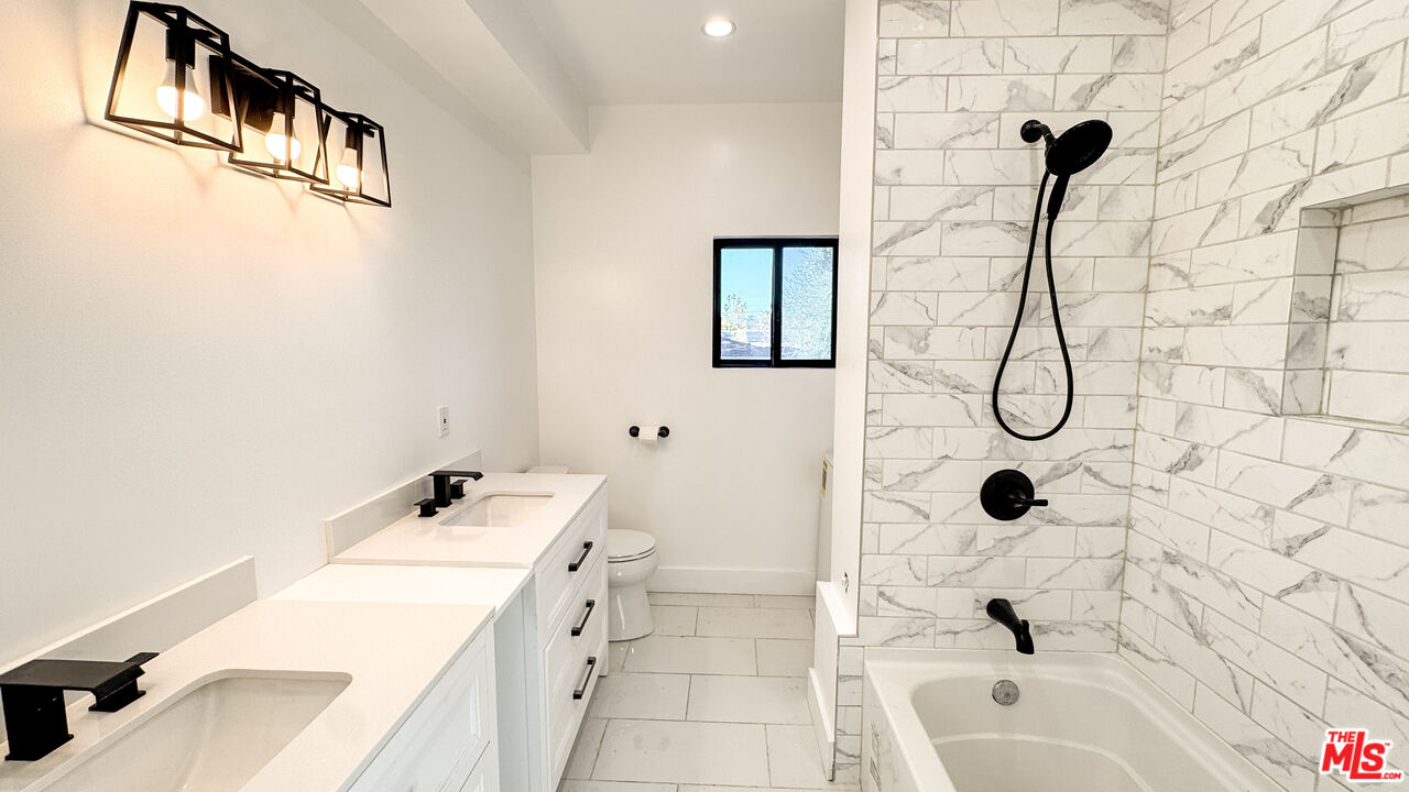19557 Calvert Street Tarzana, CA 91335 - Photo 8 of 11 a bathroom with a tub a toilet and a shower