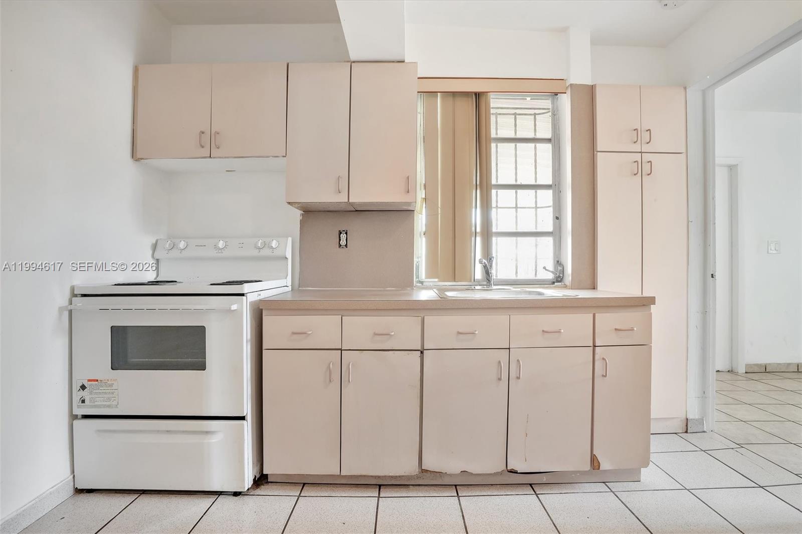 6810 Southwest 1st Street Miami, FL 33144 - Photo 11 of 17 a kitchen with white cabinets and white appliances