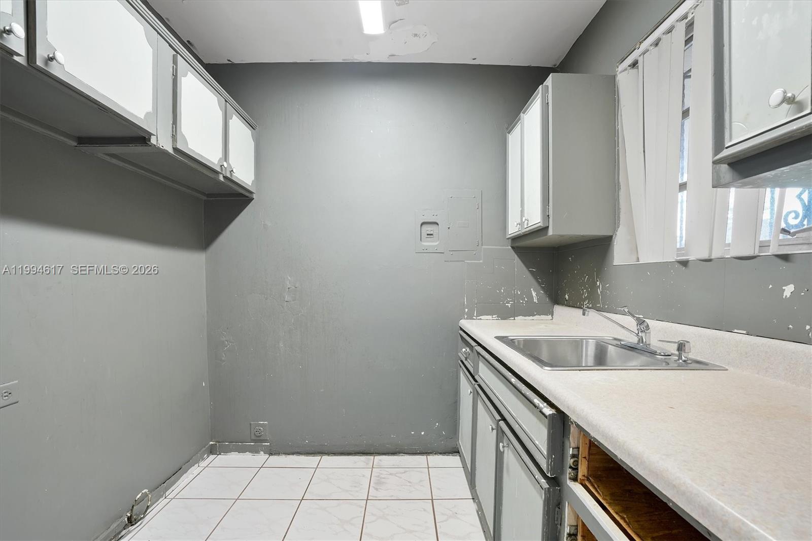 6810 Southwest 1st Street Miami, FL 33144 - Photo 7 of 17 a kitchen with a sink cabinets and utility