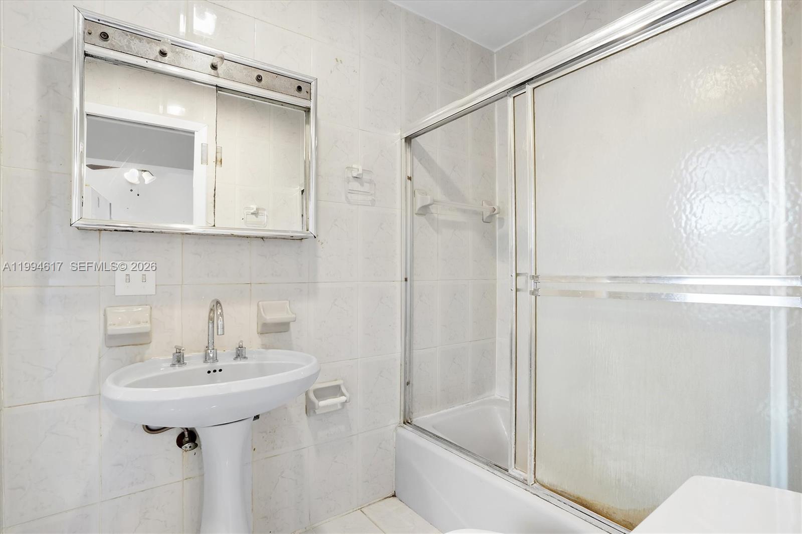 6810 Southwest 1st Street Miami, FL 33144 - Photo 9 of 17 a bathroom with a sink a mirror a bathtub and shower