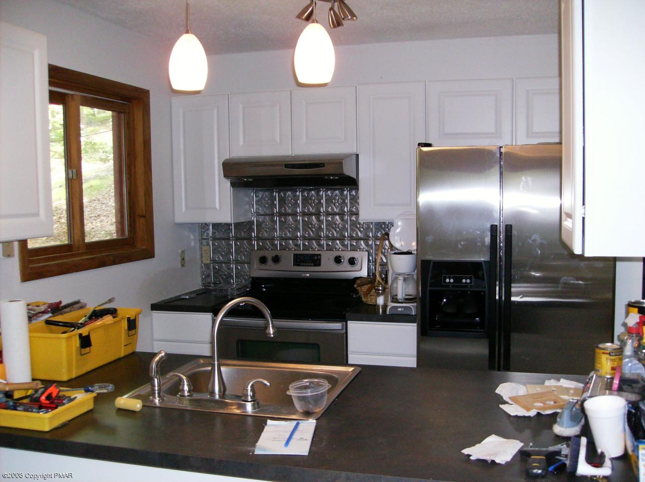2727 Radcliff Road Bushkill, PA 18324 - Photo 4 of 14 a kitchen with a sink stainless steel appliances and dining table