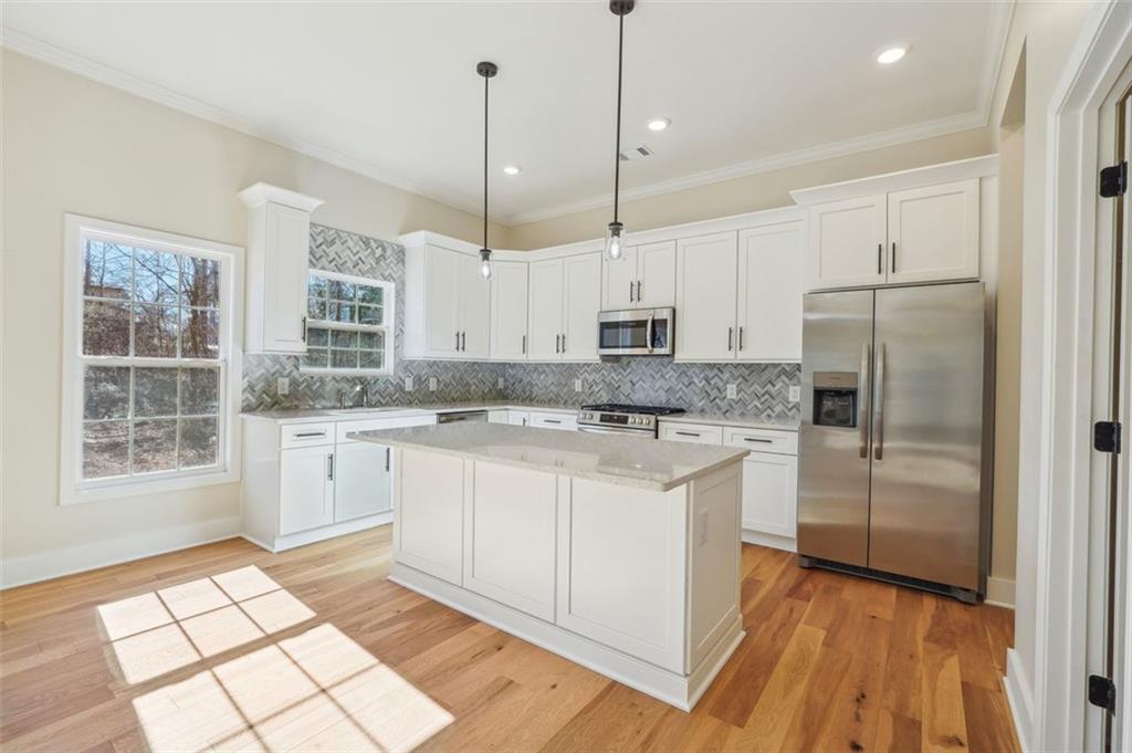 1620 Derry Avenue Southwest Atlanta, GA 30310 - Photo 13 of 47 a kitchen with stainless steel appliances granite countertop a refrigerator a sink a stove and white cabinets with wooden floor