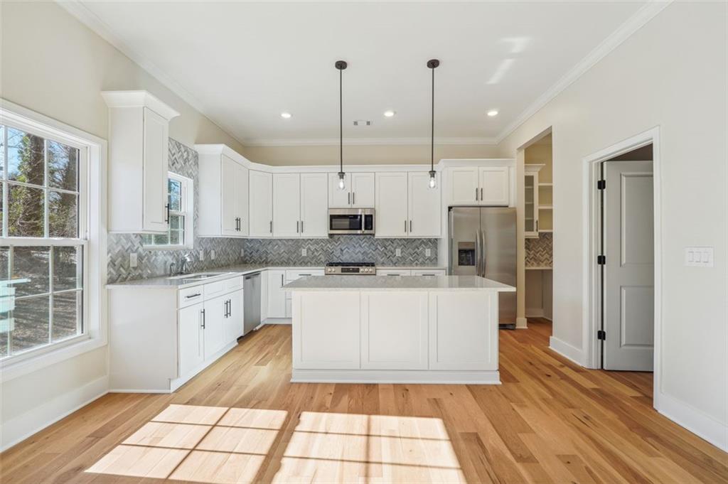 1620 Derry Avenue Southwest Atlanta, GA 30310 - Photo 14 of 47 a kitchen with stainless steel appliances granite countertop a refrigerator a sink a stove and white cabinets with wooden floor