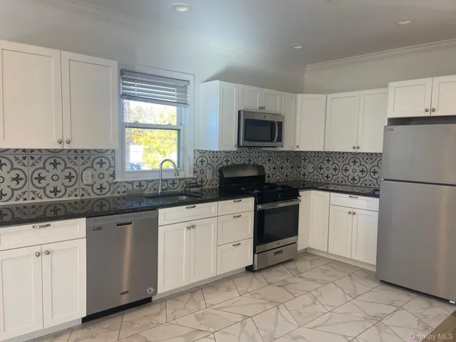 a bathroom with a granite countertop toilet a sink and a shower