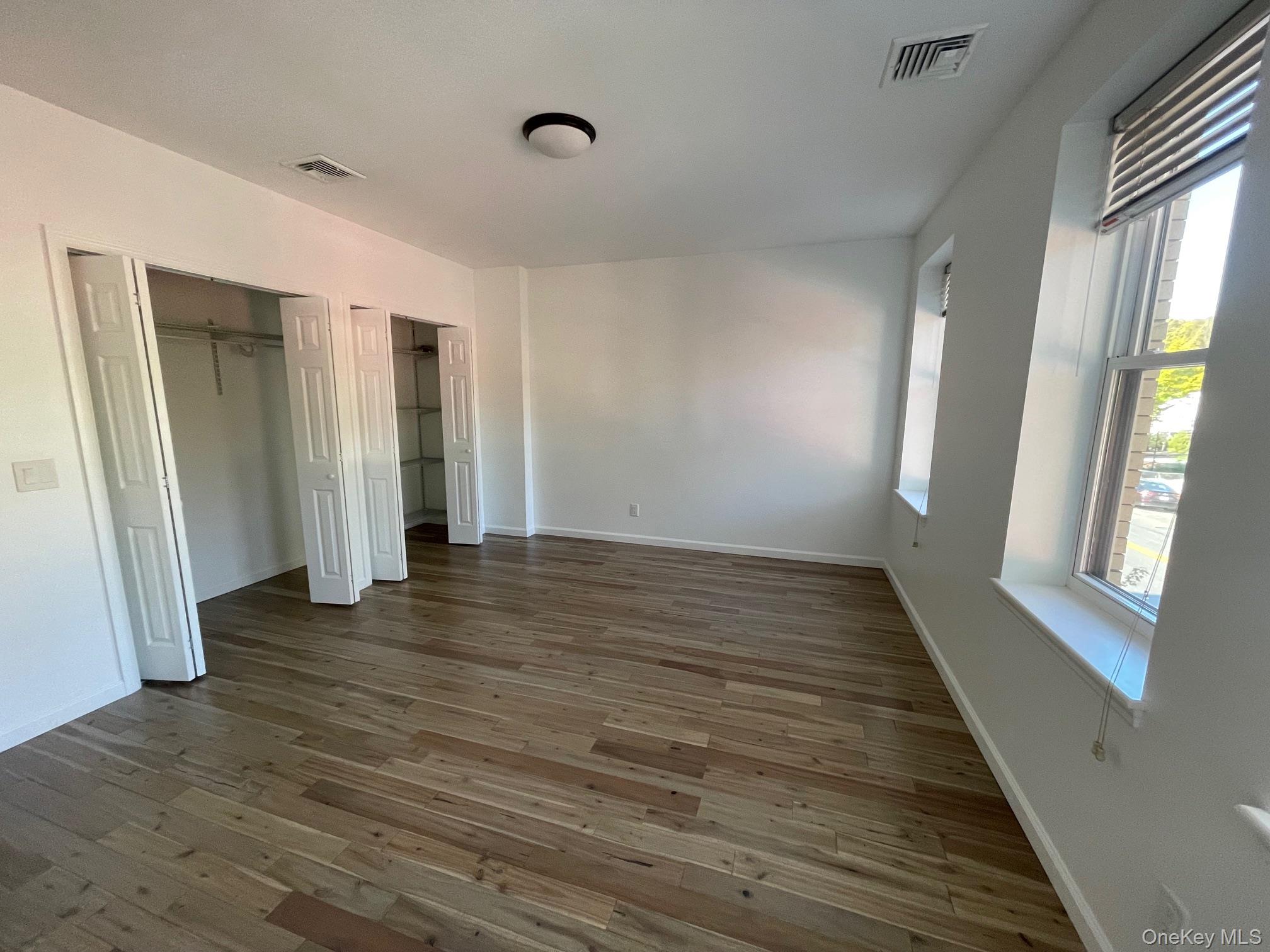 1049 Main Street, Unit 2 Peekskill, NY 10566 - Photo 6 of 9 a view of an empty room with wooden floor and a window