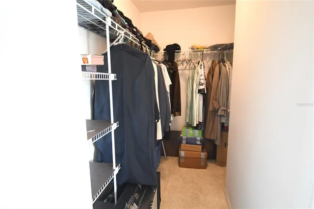 a close view of walk in closet with clothes