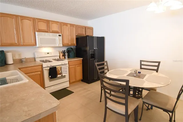 a kitchen with a stove a refrigerator and a table
