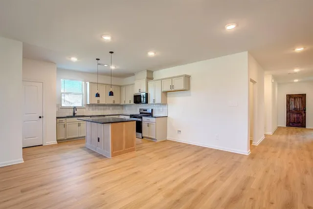 a kitchen with granite countertop a sink cabinets and wooden floor