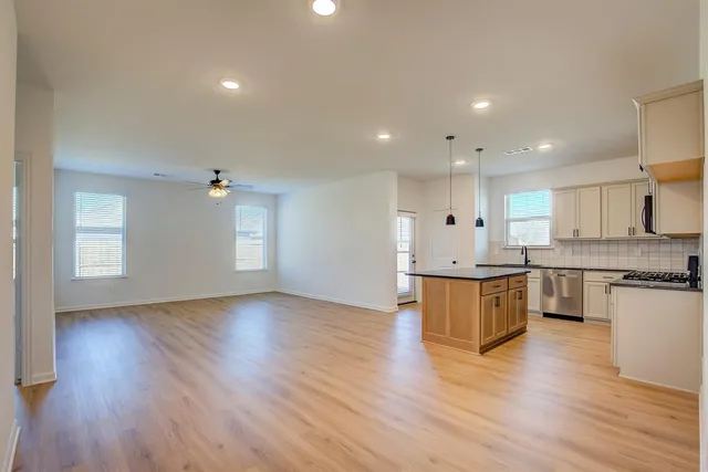a large kitchen with a wooden floor and a large window