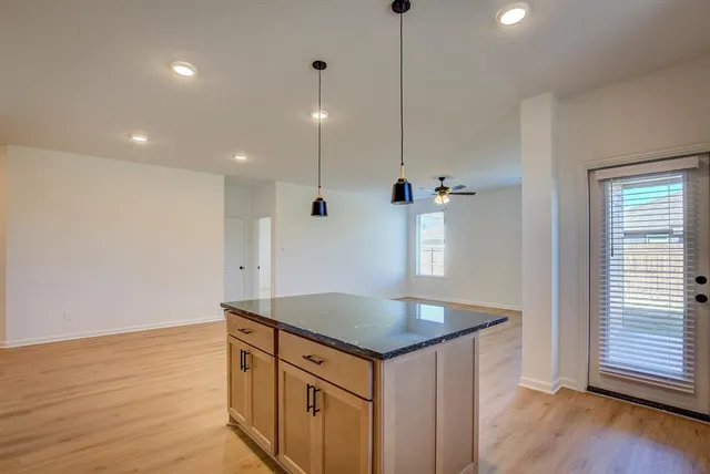 a kitchen with a sink chandelier and wooden floor