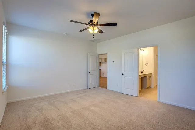 a view of a livingroom with a ceiling fan and window