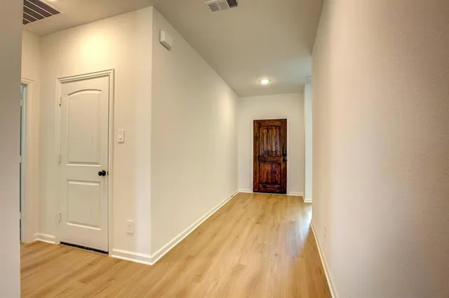 a view of a hallway with wooden floor
