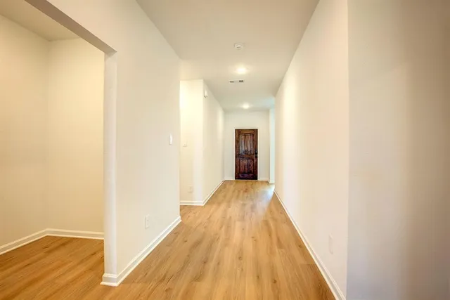 a view of hallway with wooden floor