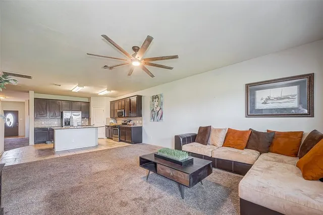 a living room with furniture and kitchen view