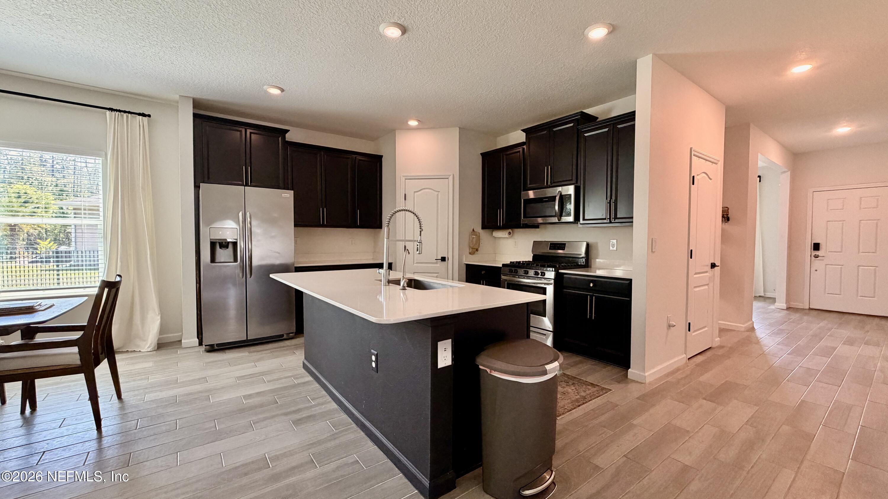 37 Saba Lane St. Augustine, FL 32092 - Photo 16 of 42 a kitchen with stainless steel appliances kitchen island granite countertop a refrigerator a sink a stove a microwave and island