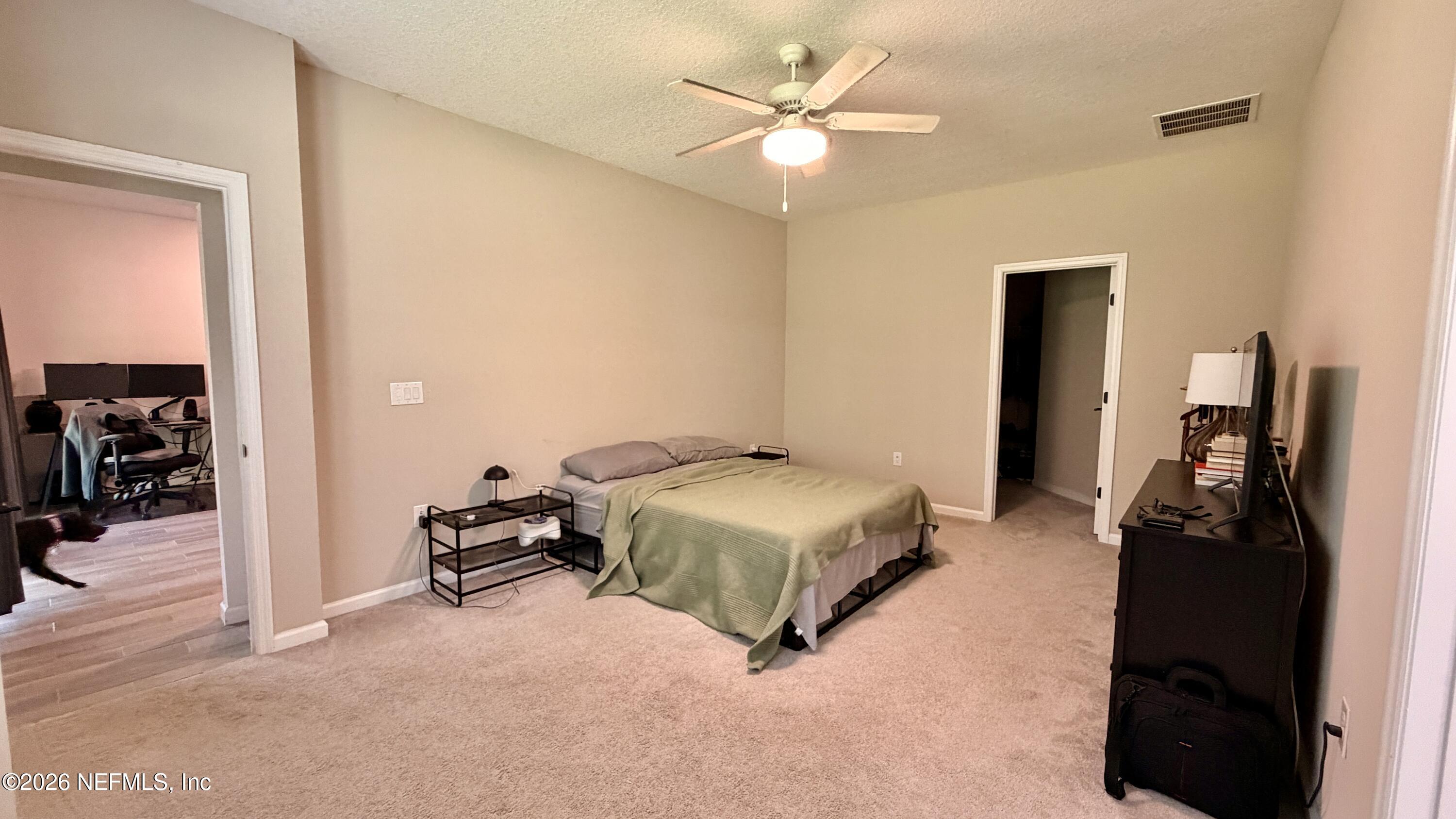 37 Saba Lane St. Augustine, FL 32092 - Photo 26 of 42 a bedroom with a bed and a chandelier