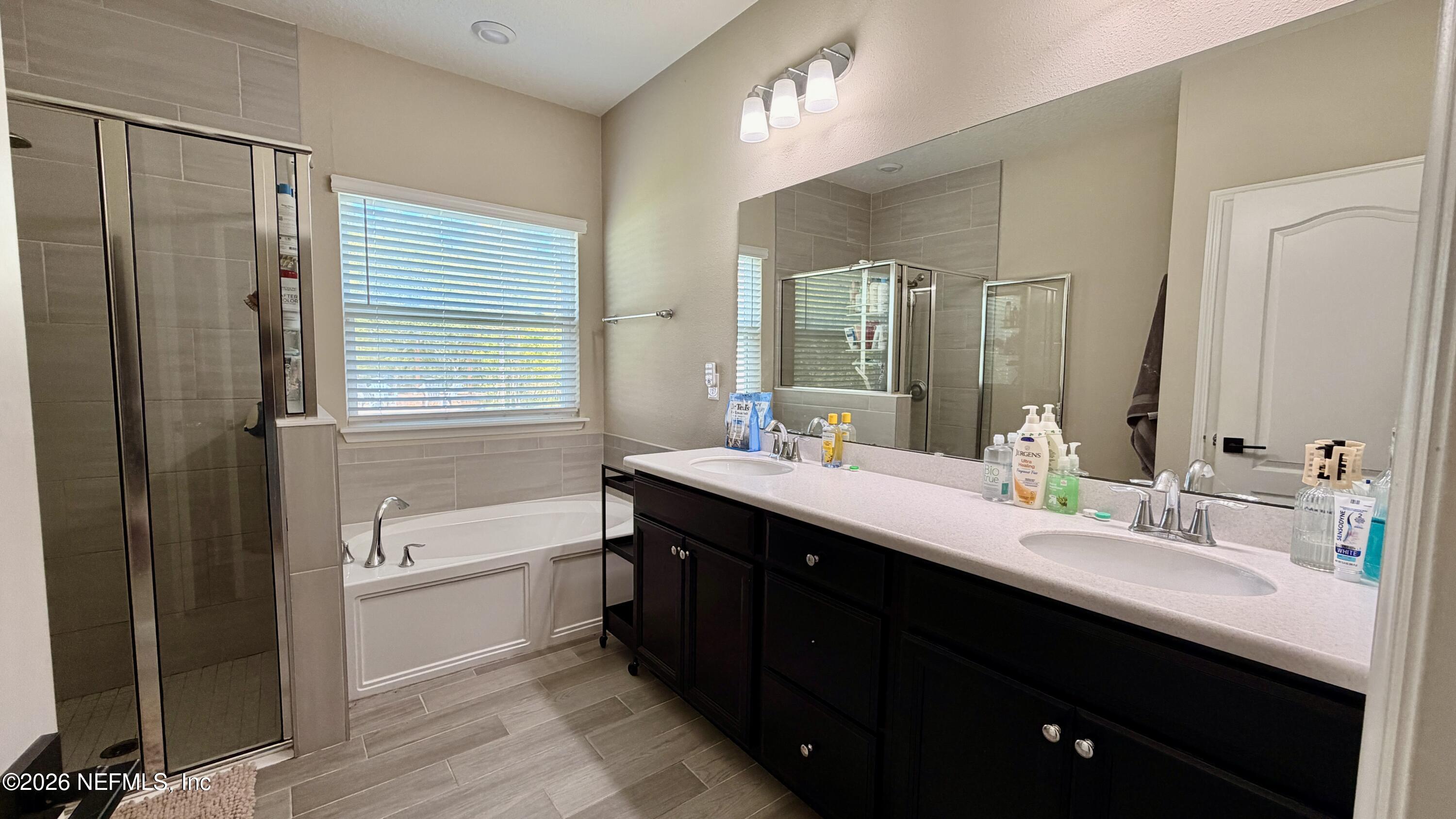 37 Saba Lane St. Augustine, FL 32092 - Photo 28 of 42 a bathroom with a double vanity sink a mirror and a bathtub