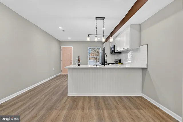 a view of a kitchen with wooden floor and a ceiling fan
