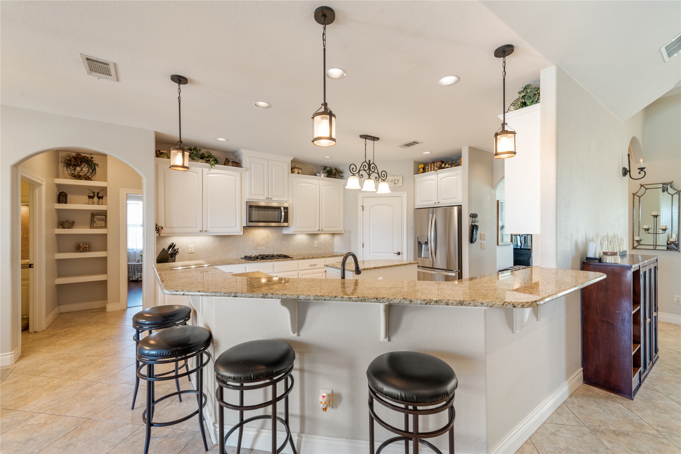 120 Layton Way Georgetown, TX 78633 - Photo 14 of 40 a kitchen with stainless steel appliances granite countertop a stove a sink a oven a dining table and chairs
