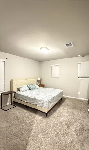 a spacious bedroom with a bed and a cabinets