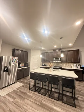 a kitchen with stainless steel appliances kitchen island granite countertop a sink and cabinets