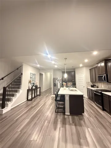 a large kitchen with a kitchen island a sink stainless steel appliances and cabinets