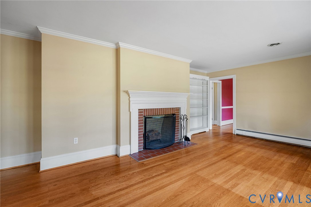 2831 Braidwood Road Richmond, VA 23225 - Photo 13 of 50 a view of an empty room with wooden floor fireplace and a window