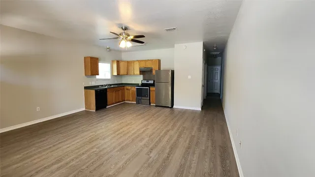 a view of a kitchen with a sink and a refrigerator