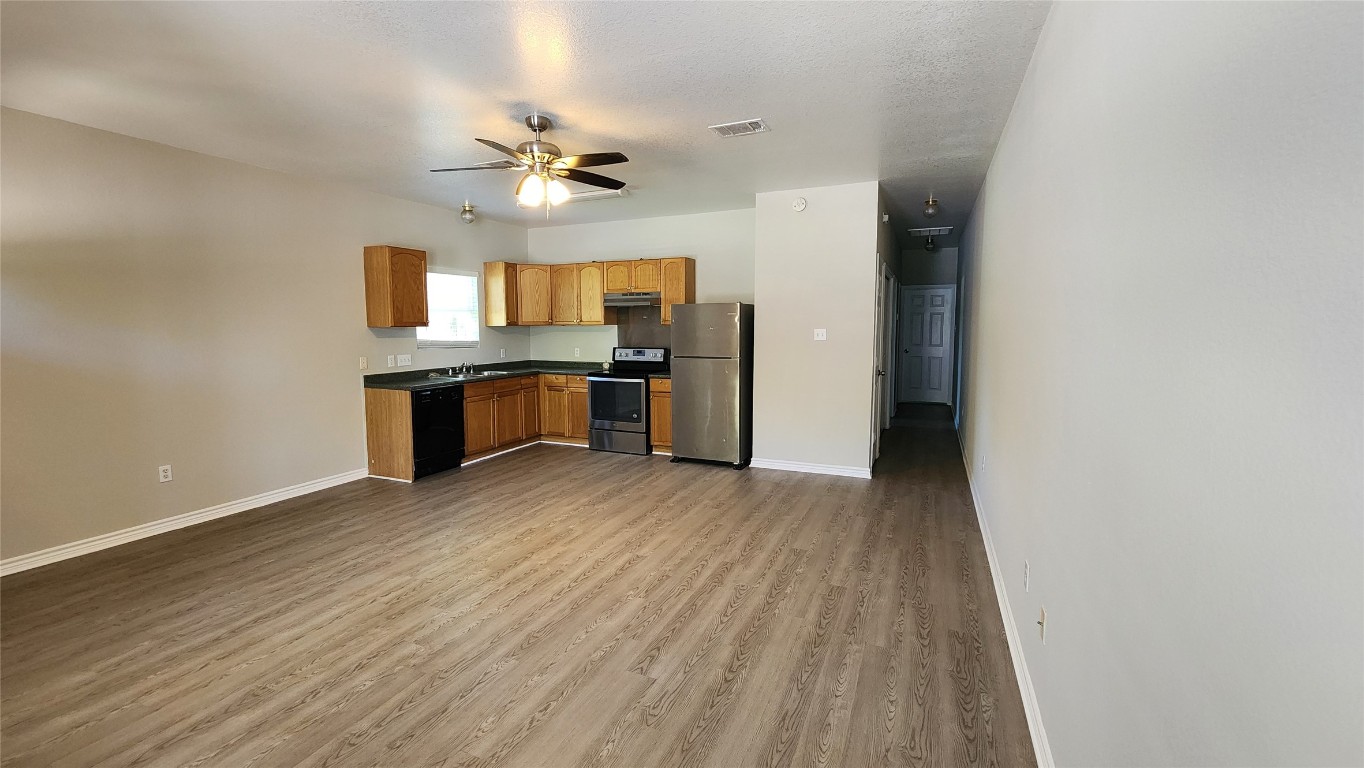 605 Martin Luther King Boulevard, Unit A Elgin, TX 78621 - Photo 5 of 18 a view of a kitchen with a sink and a refrigerator