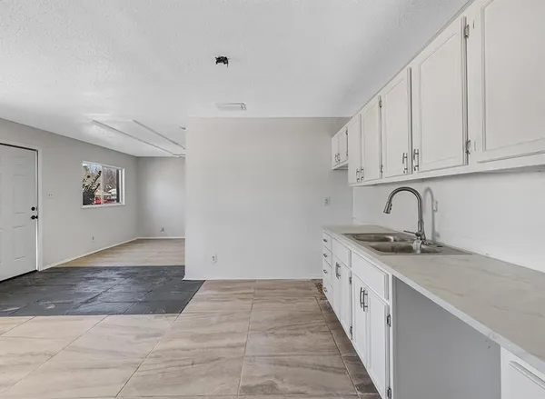 a kitchen with granite countertop a sink and cabinets