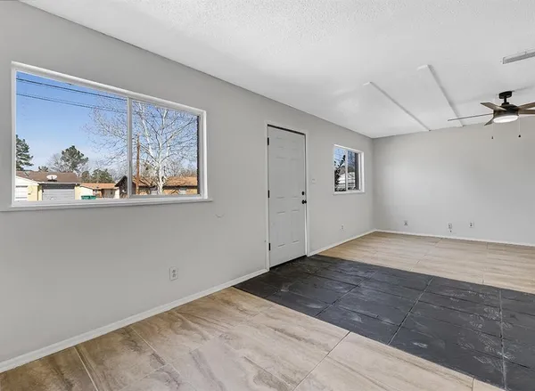 a view of a big room with wooden floor and window